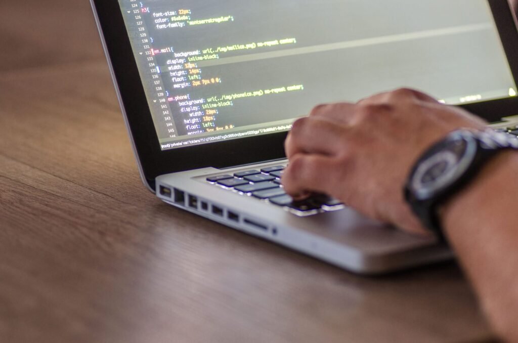 Web developer working with code on a laptop